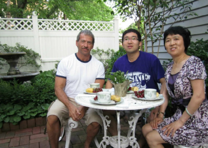 Guests from China visiting their son at K-State, enjoying breakfast in the courtyard with innkeeper Tim Lindemuth